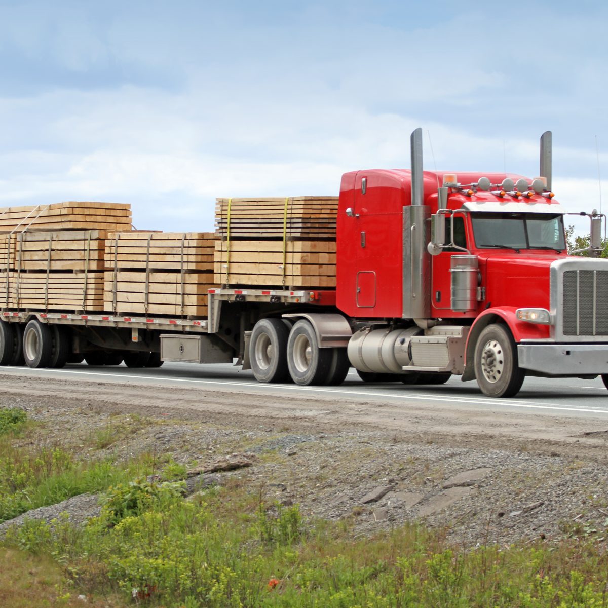 Semi Flatbed Truck Hauling A Load Of Lumber To A Construction Site ...